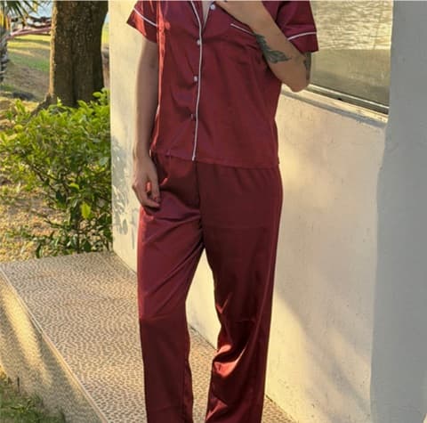 Mujer usando un conjunto de pijama de seda en tono rosa